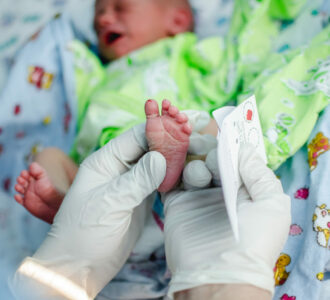 Un docteur prend un échantillon de sang d'un nouveau-né